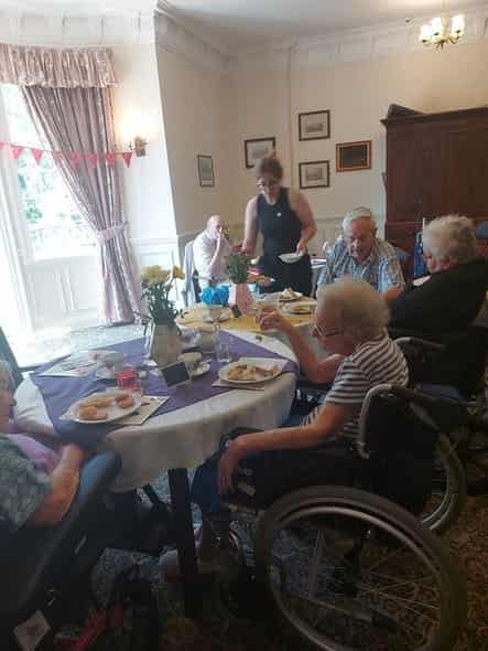 Residents dining together in the bright conservatory lounge