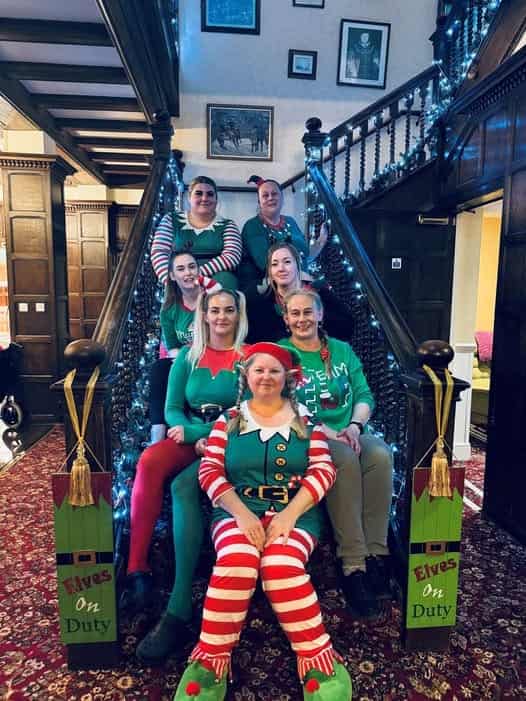 Our dedicated care team gathered on the grand manor staircase