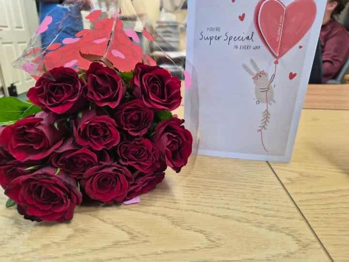 Velvet red roses and greeting card for a resident celebration